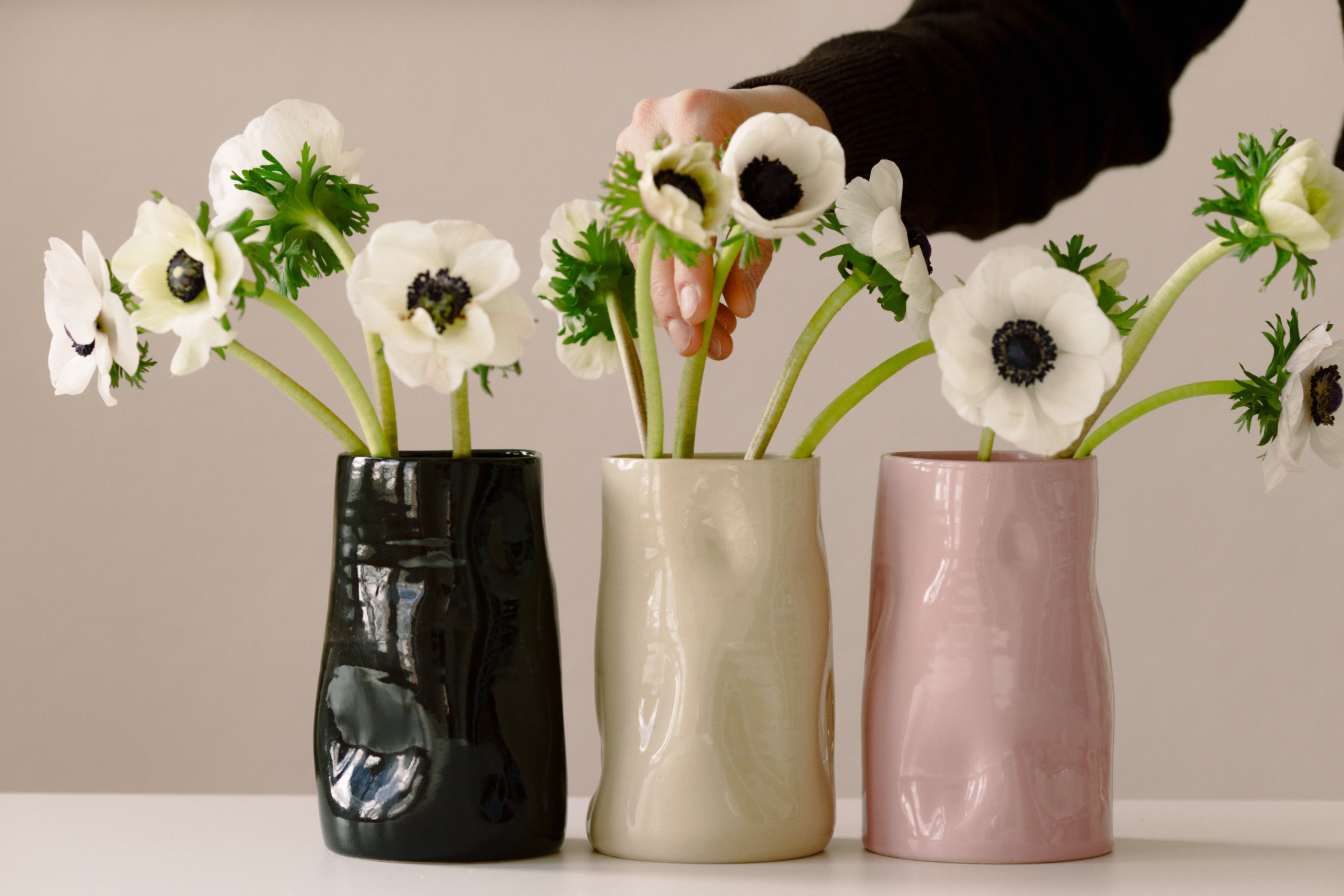 Spring ceramics collection featuring a vase with fresh flowers on a table in warm light.