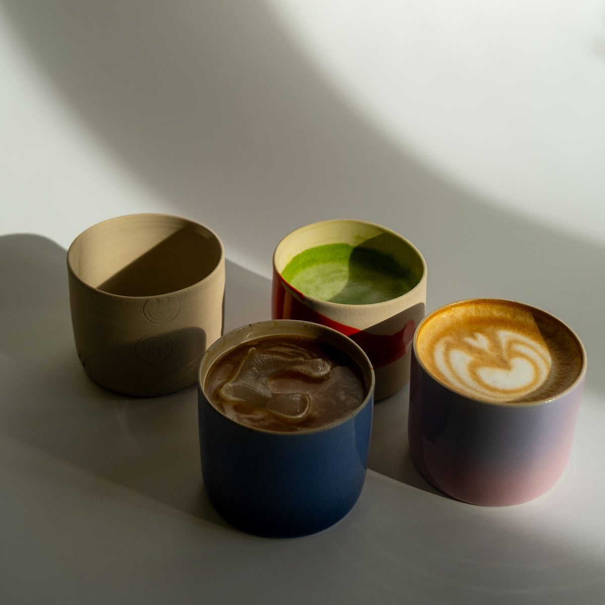 4er Set - handgemachte Kaffeebecher Set 4er in gemischten Farben auf weißem Hintergrund.