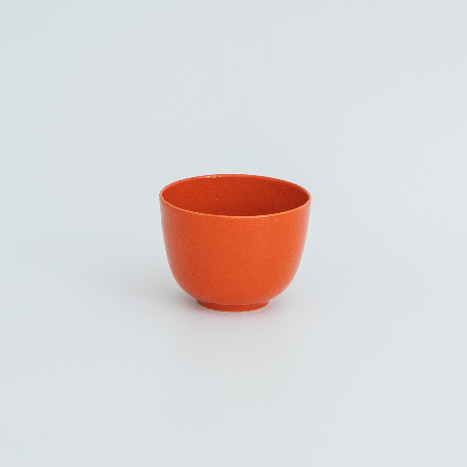 Handmade ceramic coffee cup in vibrant red color designed for everyday use.
