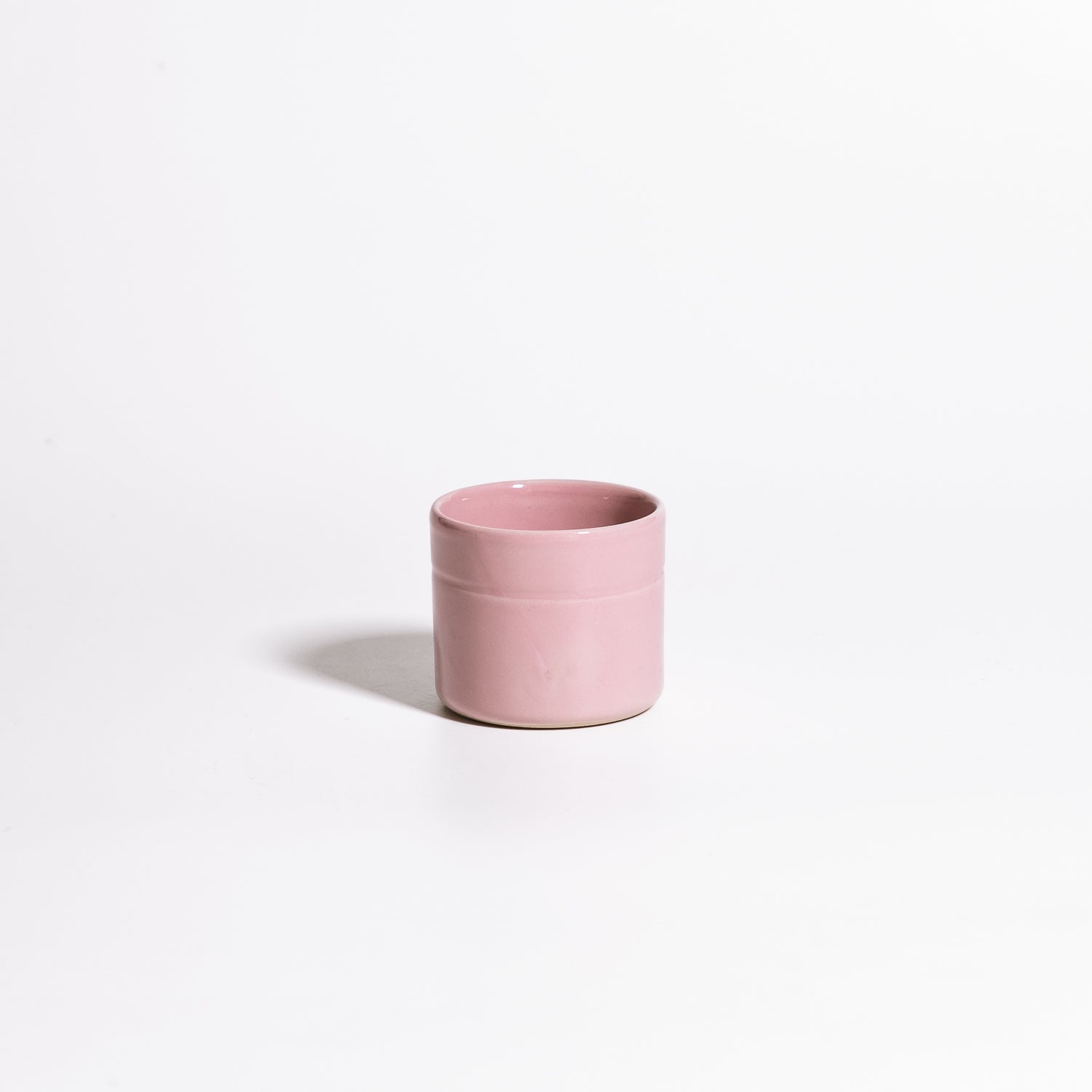 Handgemachter Keramik Espressobecher in Rosa mit elegantem Design auf weißem Hintergrund.