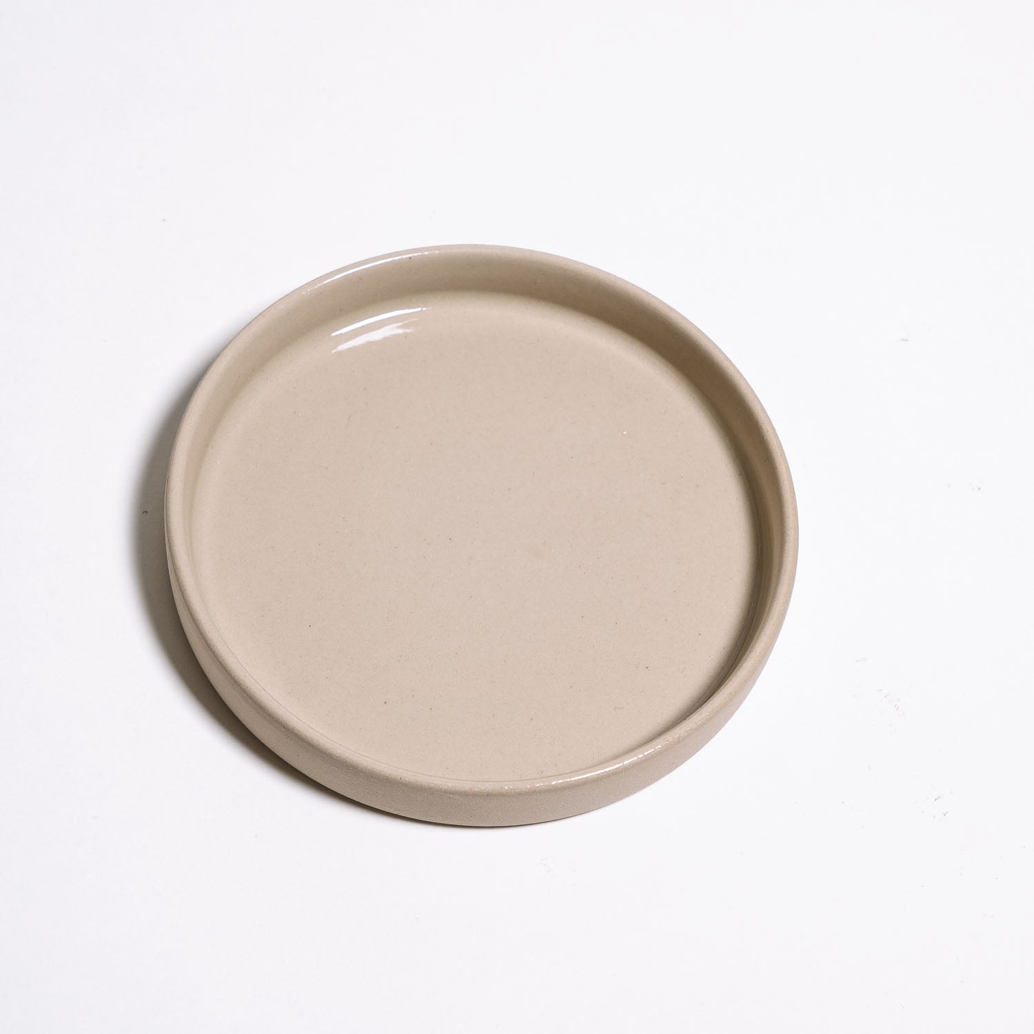 Saucer - Creme aus Steinzeug in Cremefarben mit transparentem Glanz, ideal für Tassen oder als kleine Schale.