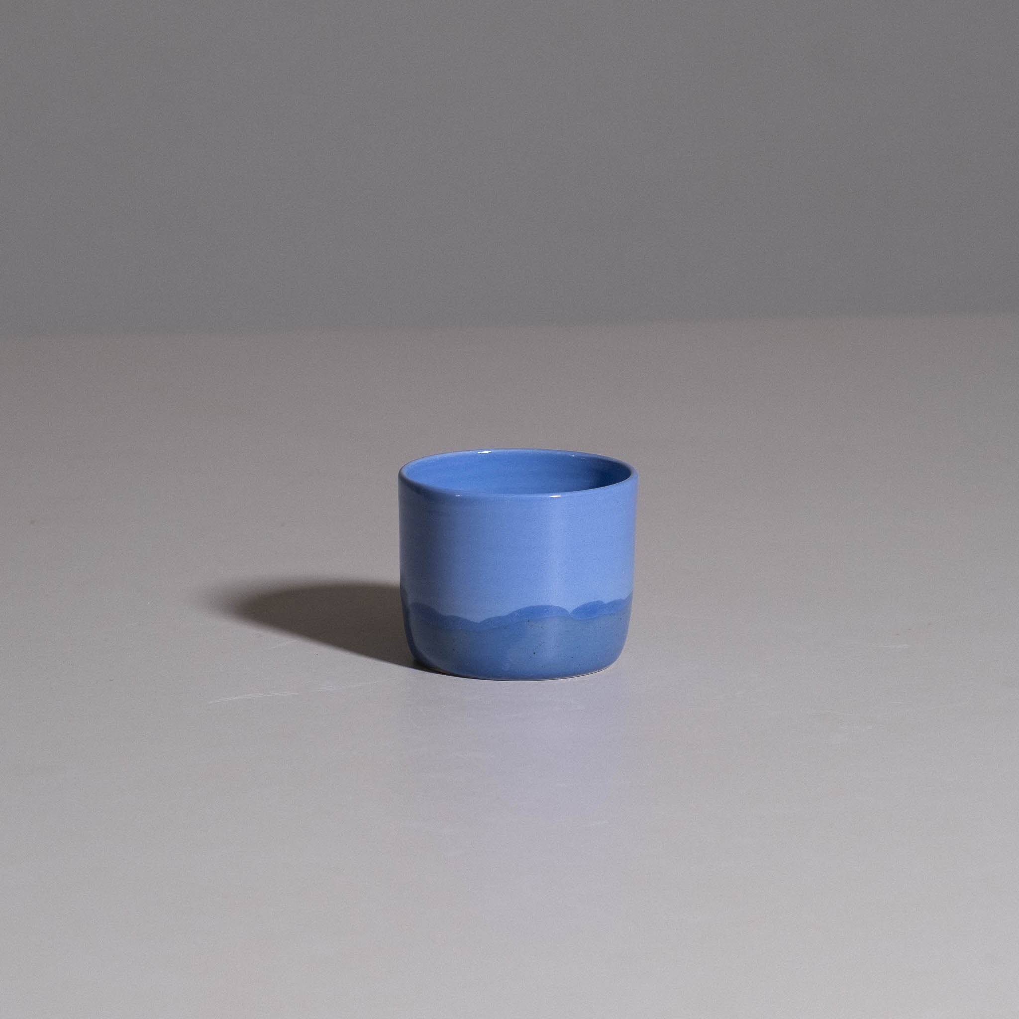 Coffee Cup – Blue aus handgemachter Keramik mit glänzend blauer Glasur und tieferem Blau zum Boden hin.