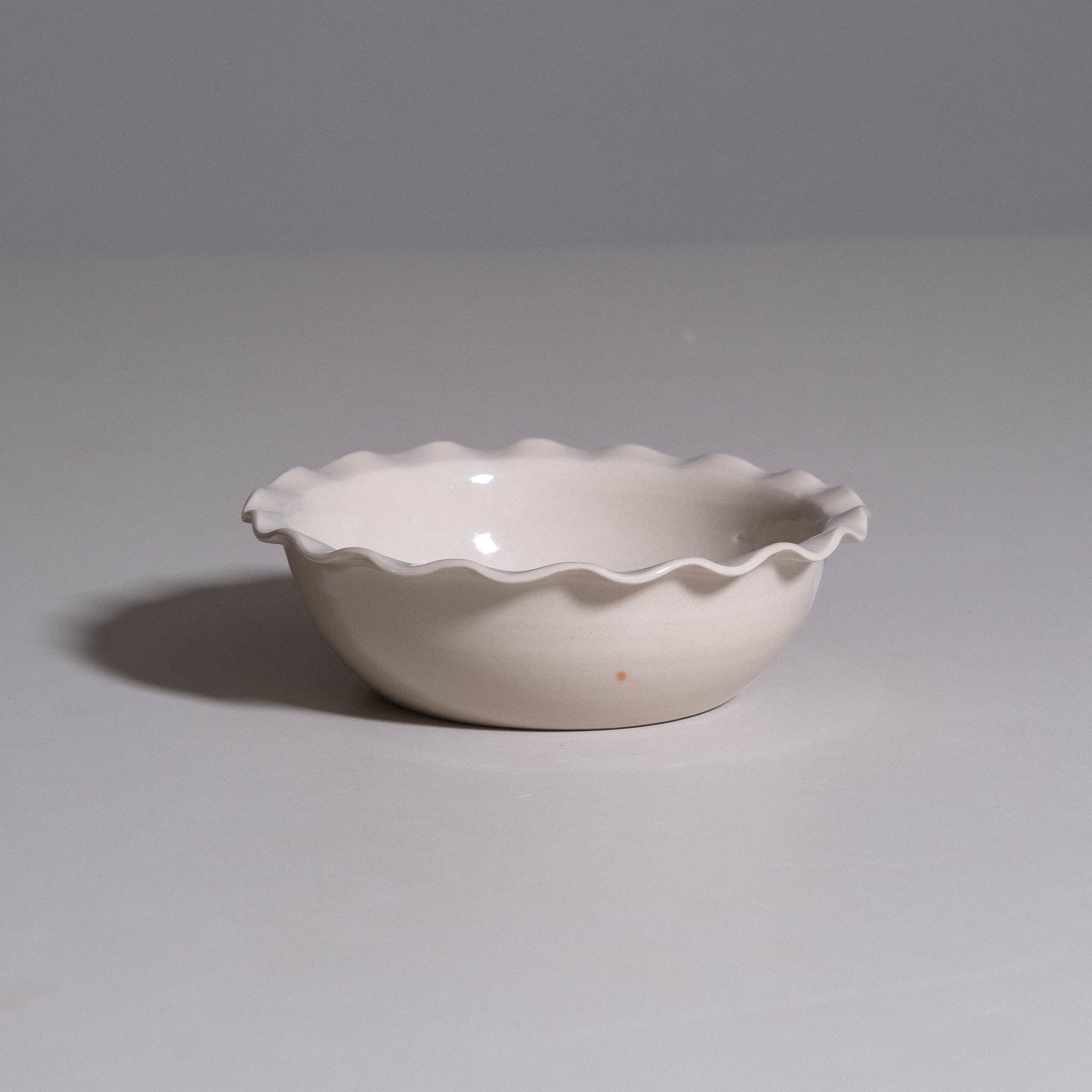 Breakfast Bowl aus handgemachter Keramik mit welligem Rand und warmer creme Glasur.