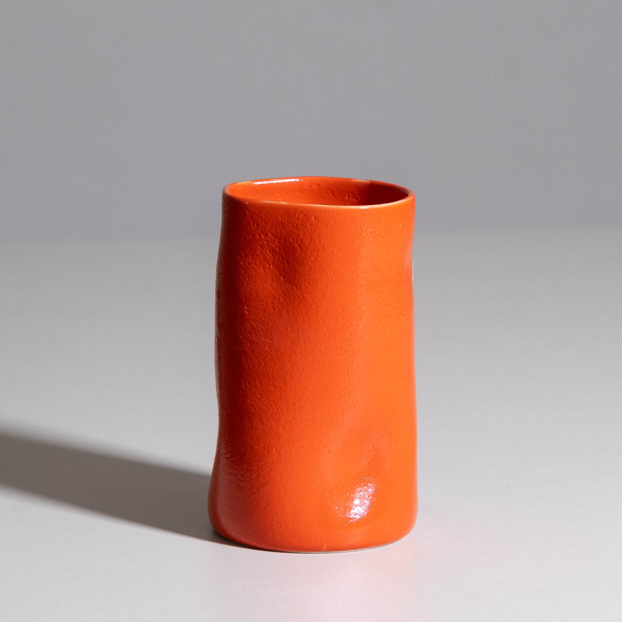 Vase aus handgemachter Keramik mit roter Glasur, seitliche Ansicht.