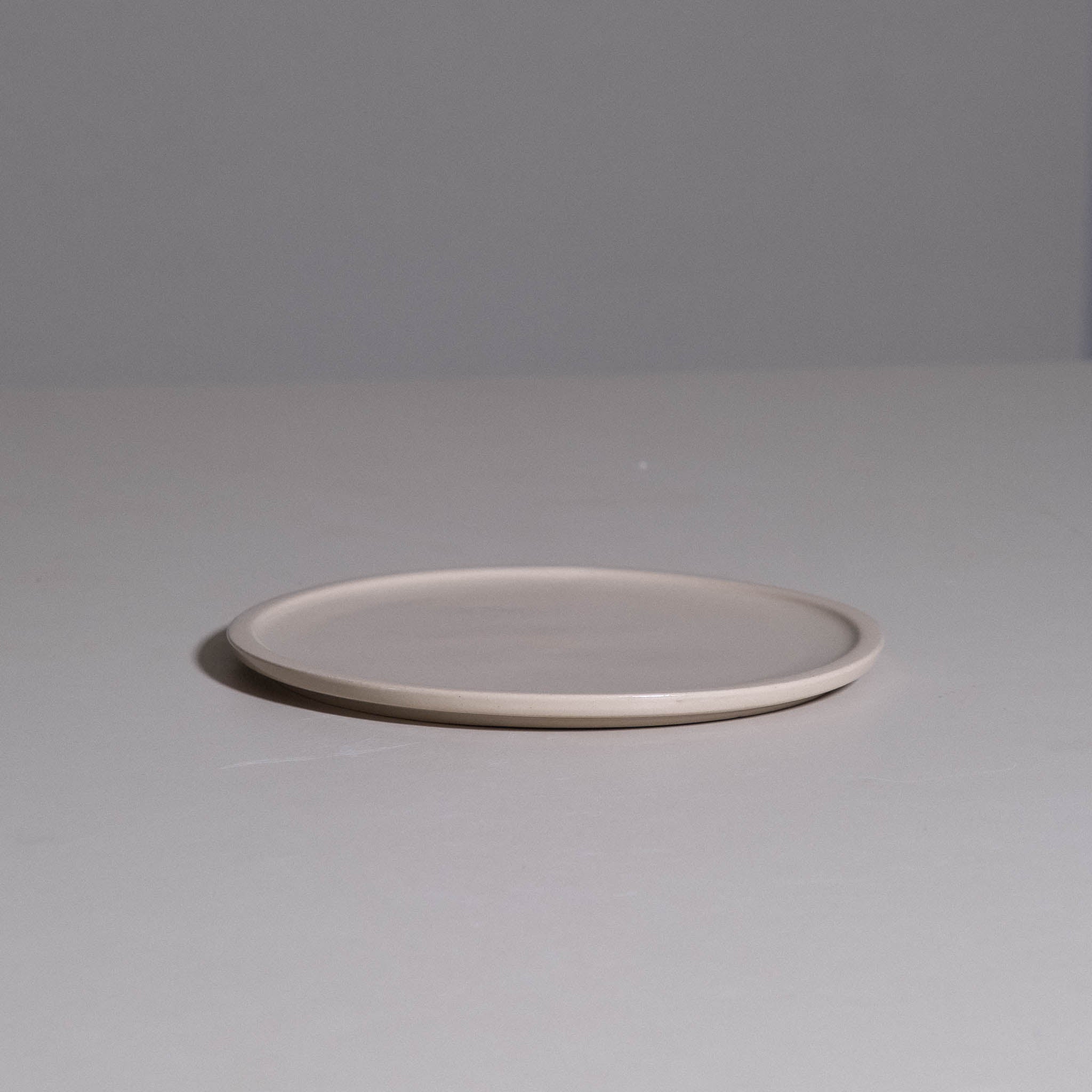 Bistro Plate aus handgemachter Keramik mit cremefarbener Glasur und schmalem Rand.