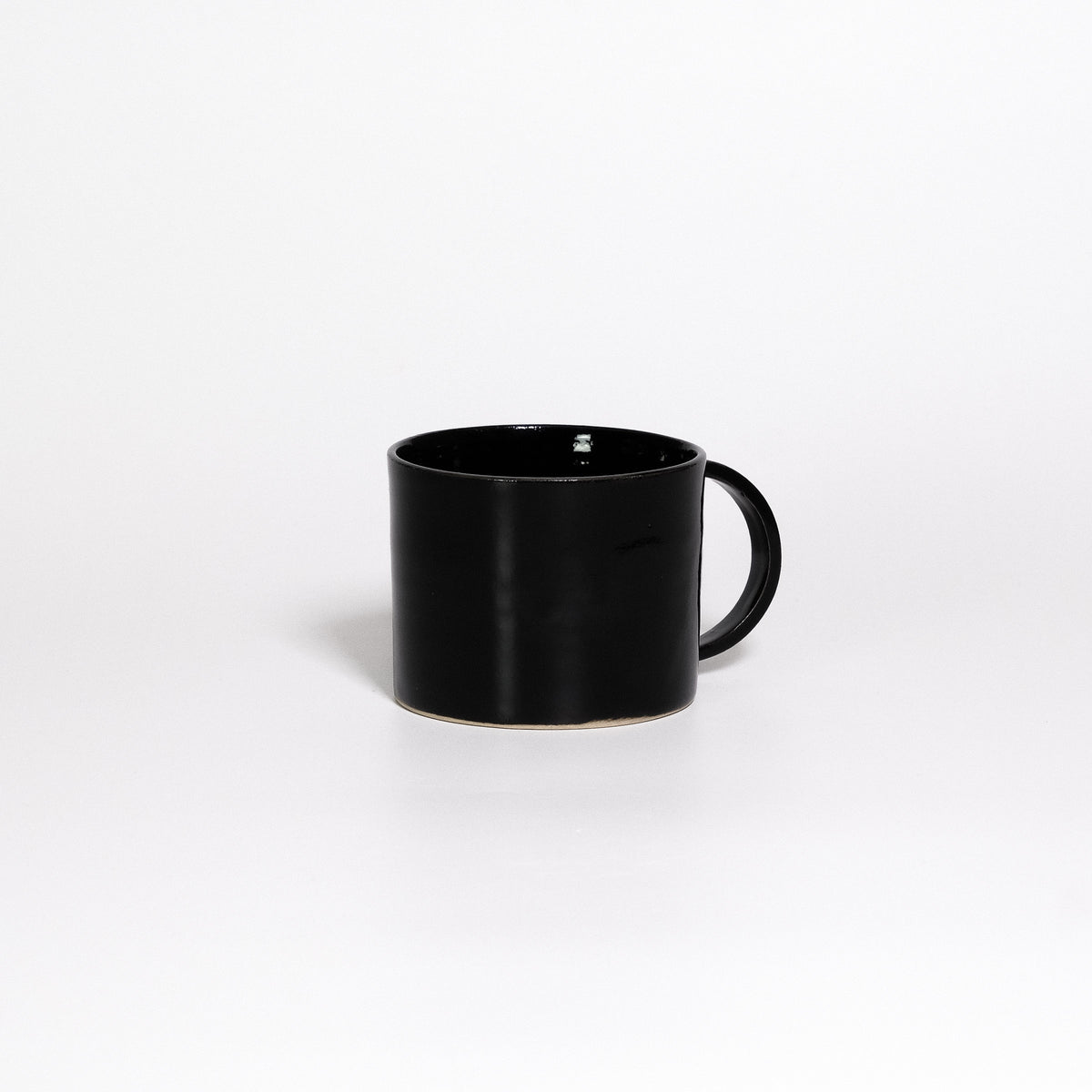 Coffee Mug Black, low wide handled stoneware mug with glossy black glaze, handle turned away