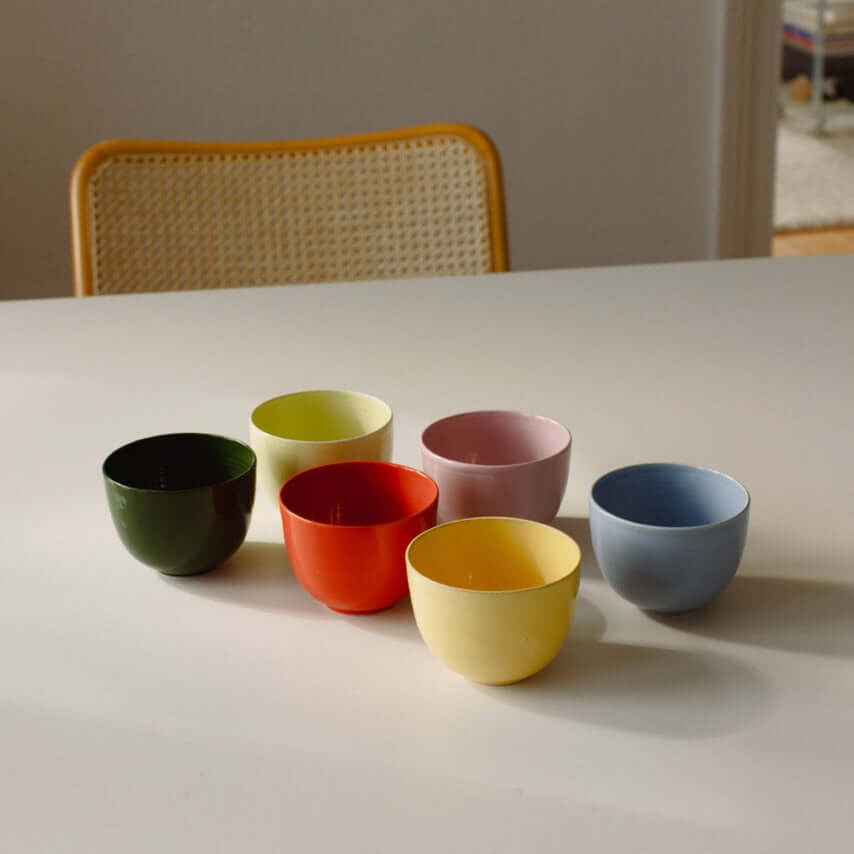 Bunte Keramiktassen, handgemacht, in verschiedenen Farben auf einem Tisch, ideal für Kaffee und Teemomente.