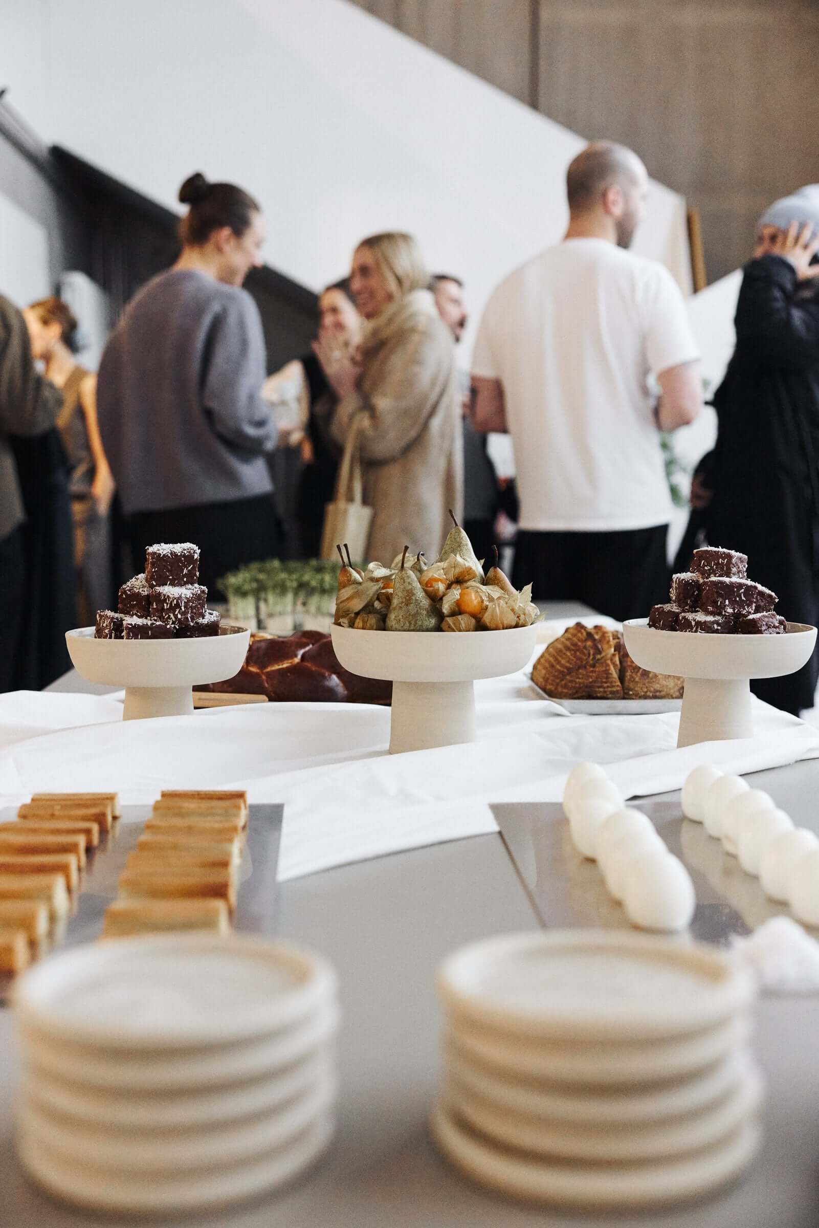 Elegant display of desserts at a social gathering, featuring pastries and confections on stylish tableware.