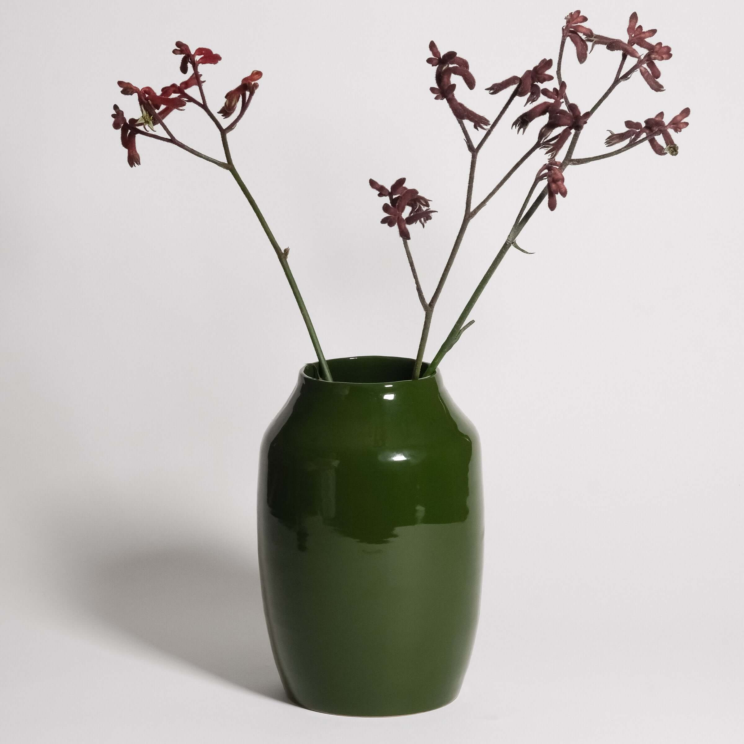 Große grüne Vase mit roten Zweigen, handgedreht aus grauem Steinzeugton, glänzende grüne Glasur.