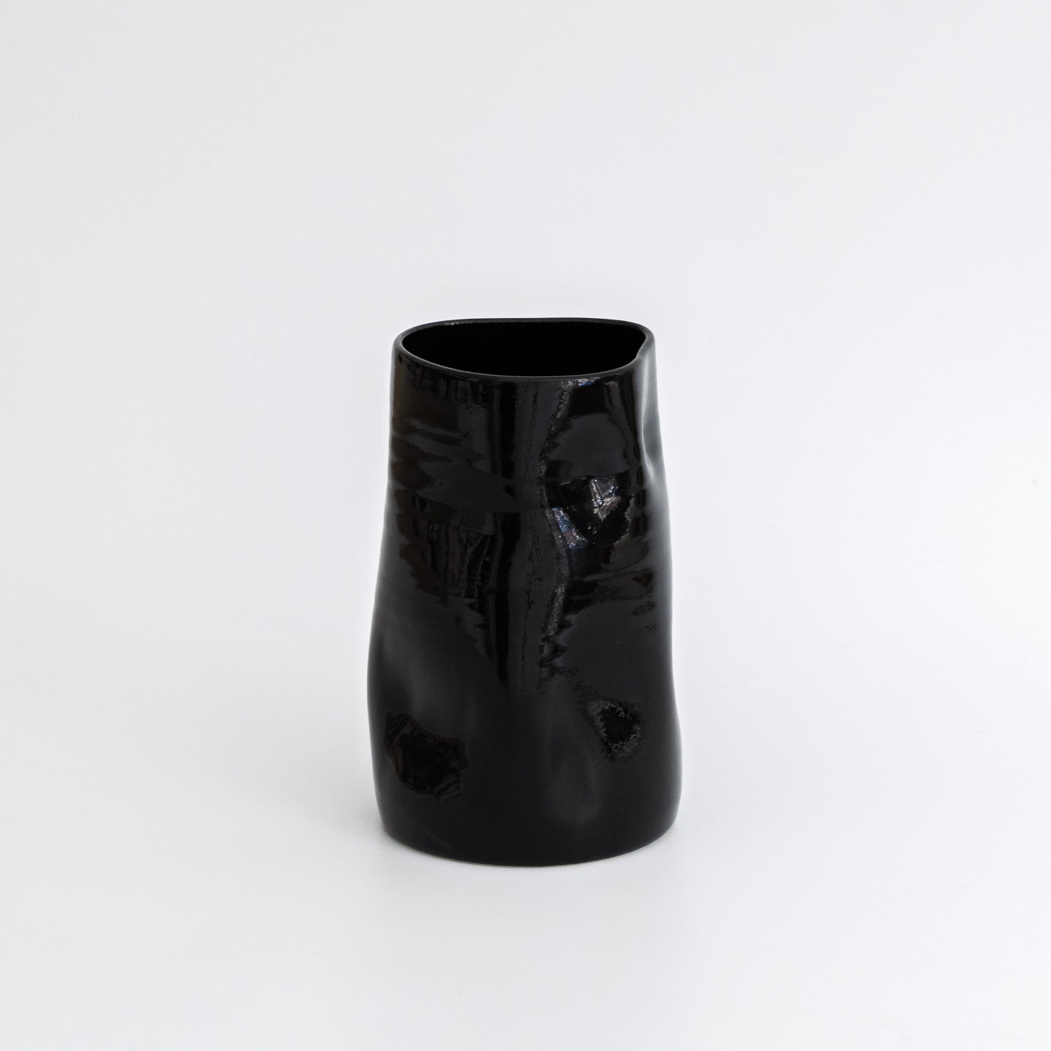 Schwarze Keramikvase – handgefertigte, glänzende Vase aus Steinzeug mit organischer Silhouette.