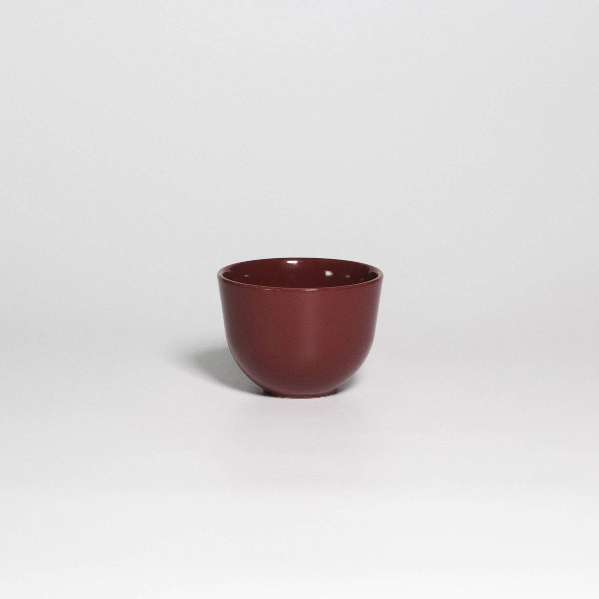 Coffee Cup Yun Rouge Noir, handleless stoneware cup with glossy rouge noir glaze, front view