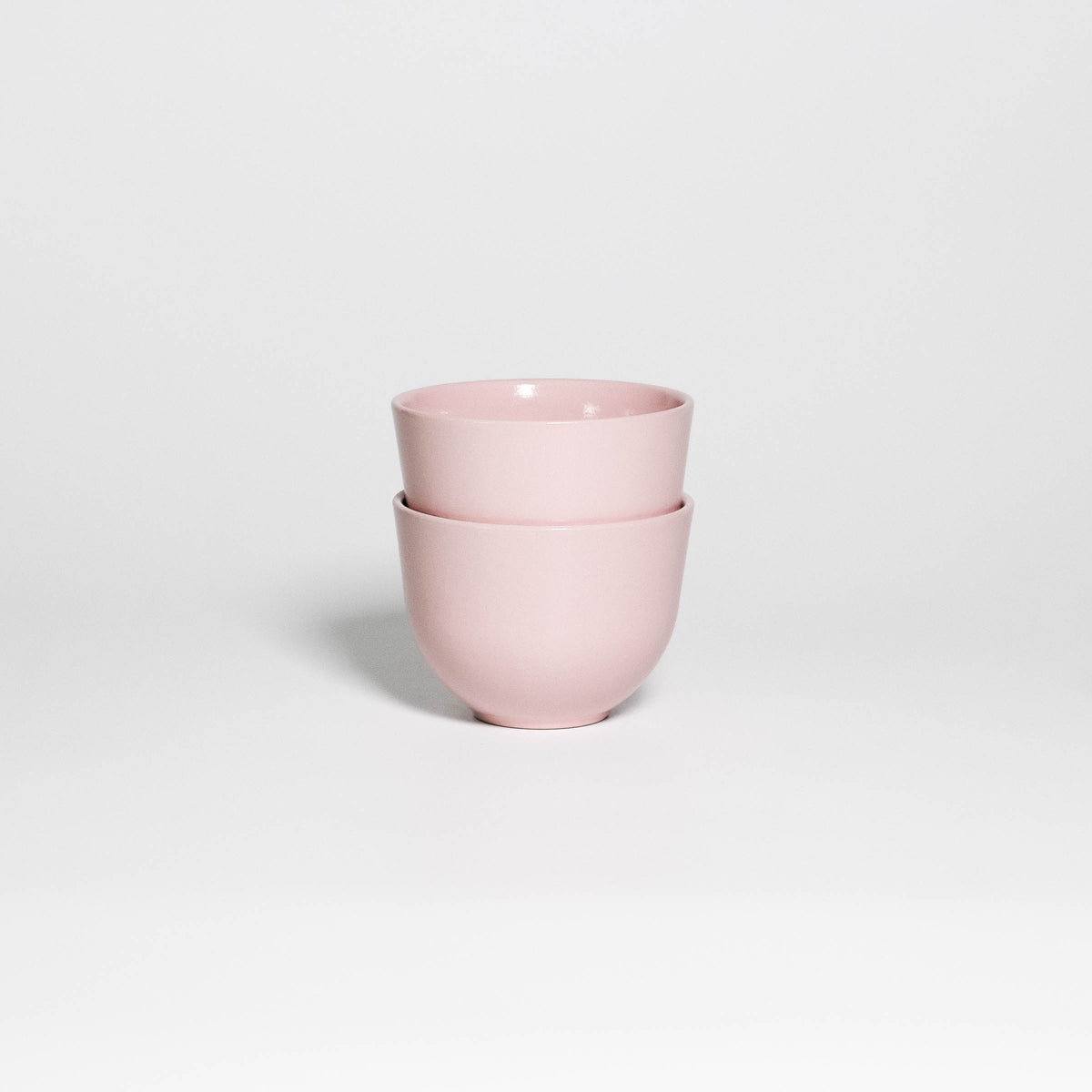 Two Coffee Cups Yun Pink stacked, handleless stoneware cups with glossy soft pink glaze
