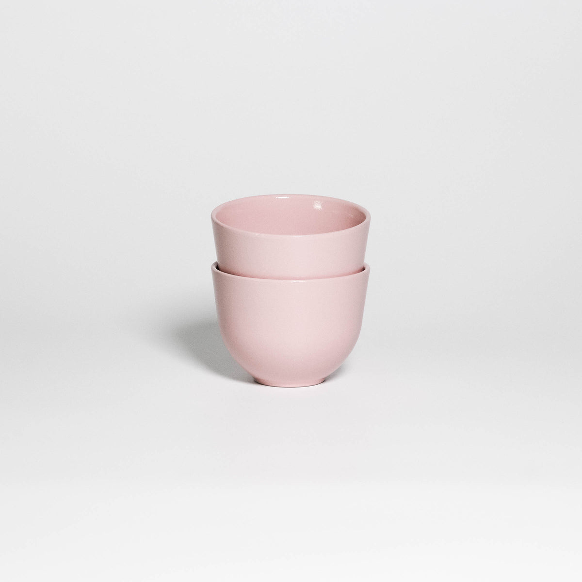 Two Coffee Cups Yun Pink stacked, handleless stoneware cups with glossy soft pink glaze, second view