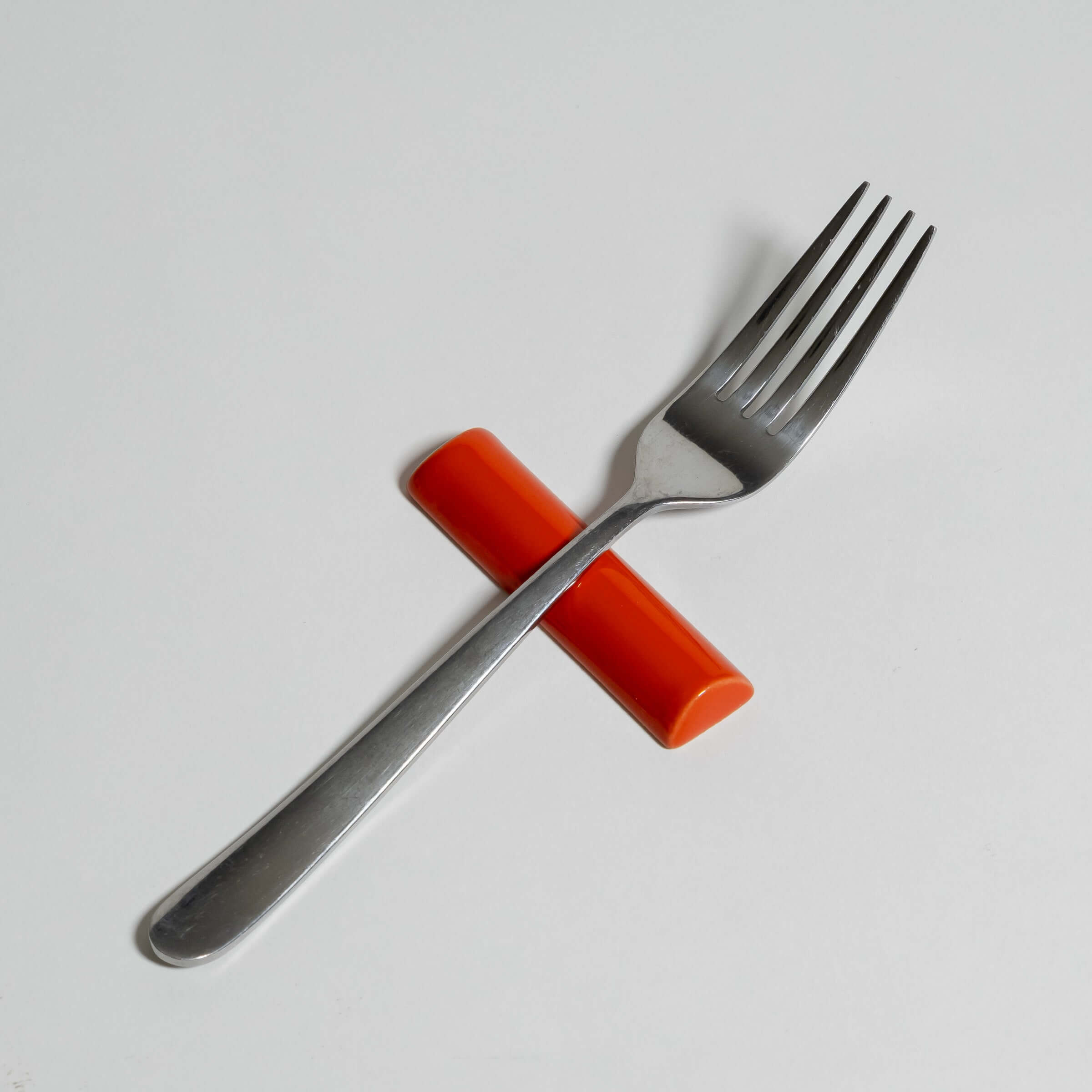 Handgefertigte Besteckablage mehrfarbig mit einer Gabel auf einem orangefarbenen Halter.