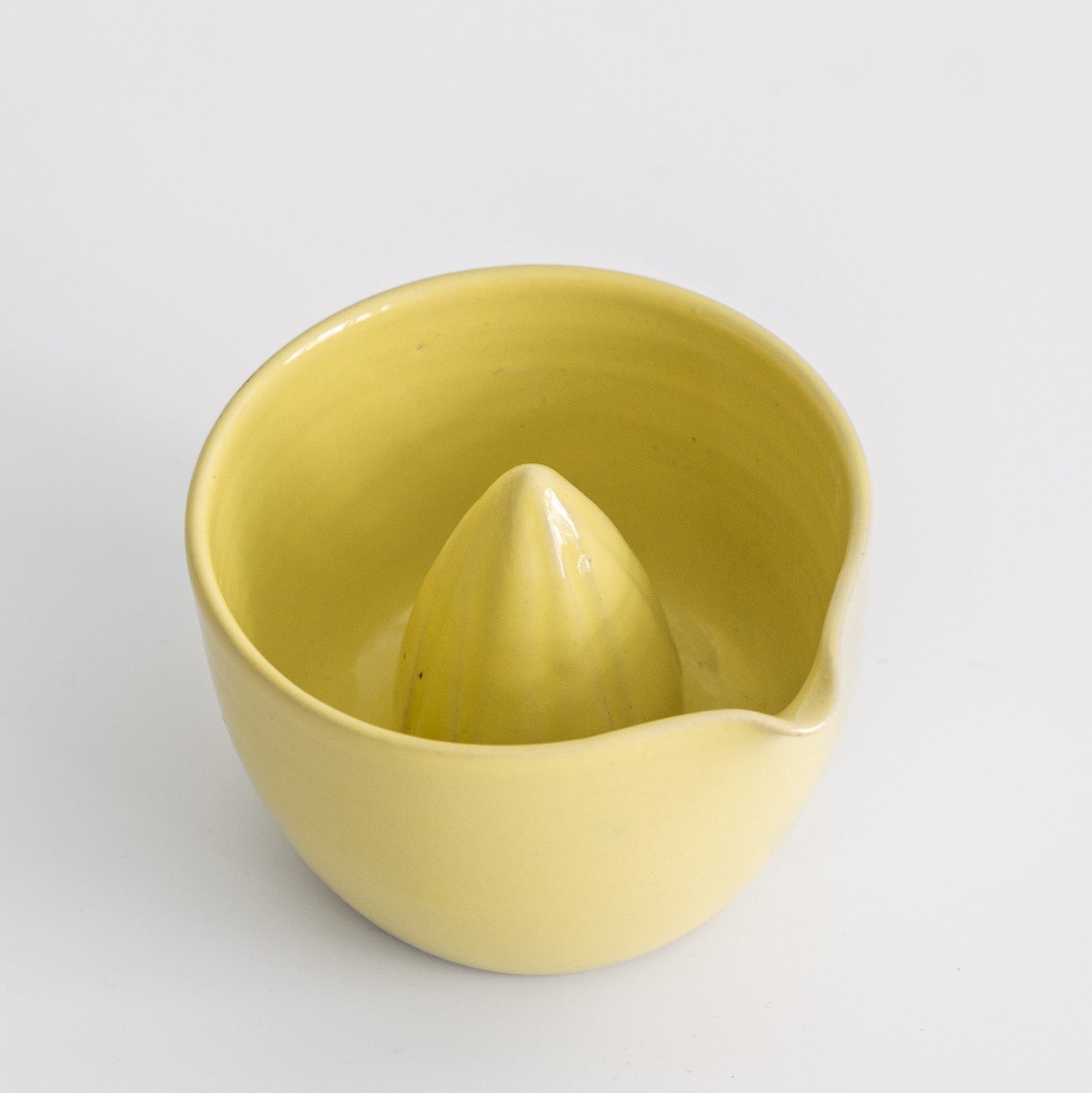 Handgemachte Zitronenpresse aus Steinzeug in Neon Gelb für die einfache Zubereitung von frisch gepresstem Saft.