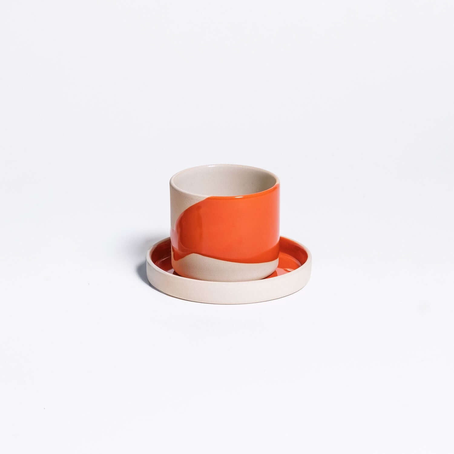 Kaffeetassen-Bundle - Splash Red mit orangefarbener Tasse und passendem Unterteller auf weißem Hintergrund