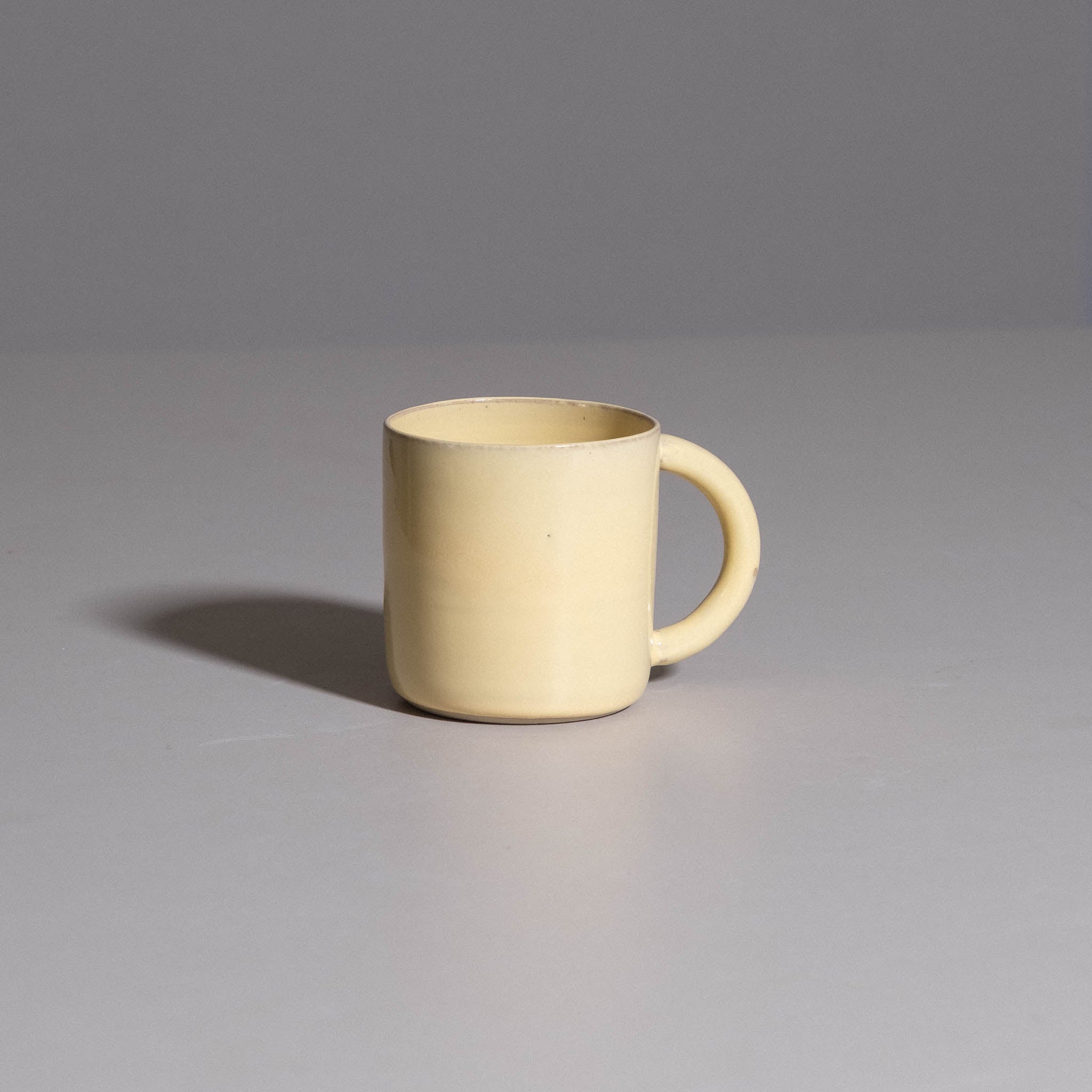 Coffee Mug aus handgemachter Keramik mit warmer gelber Glasur.