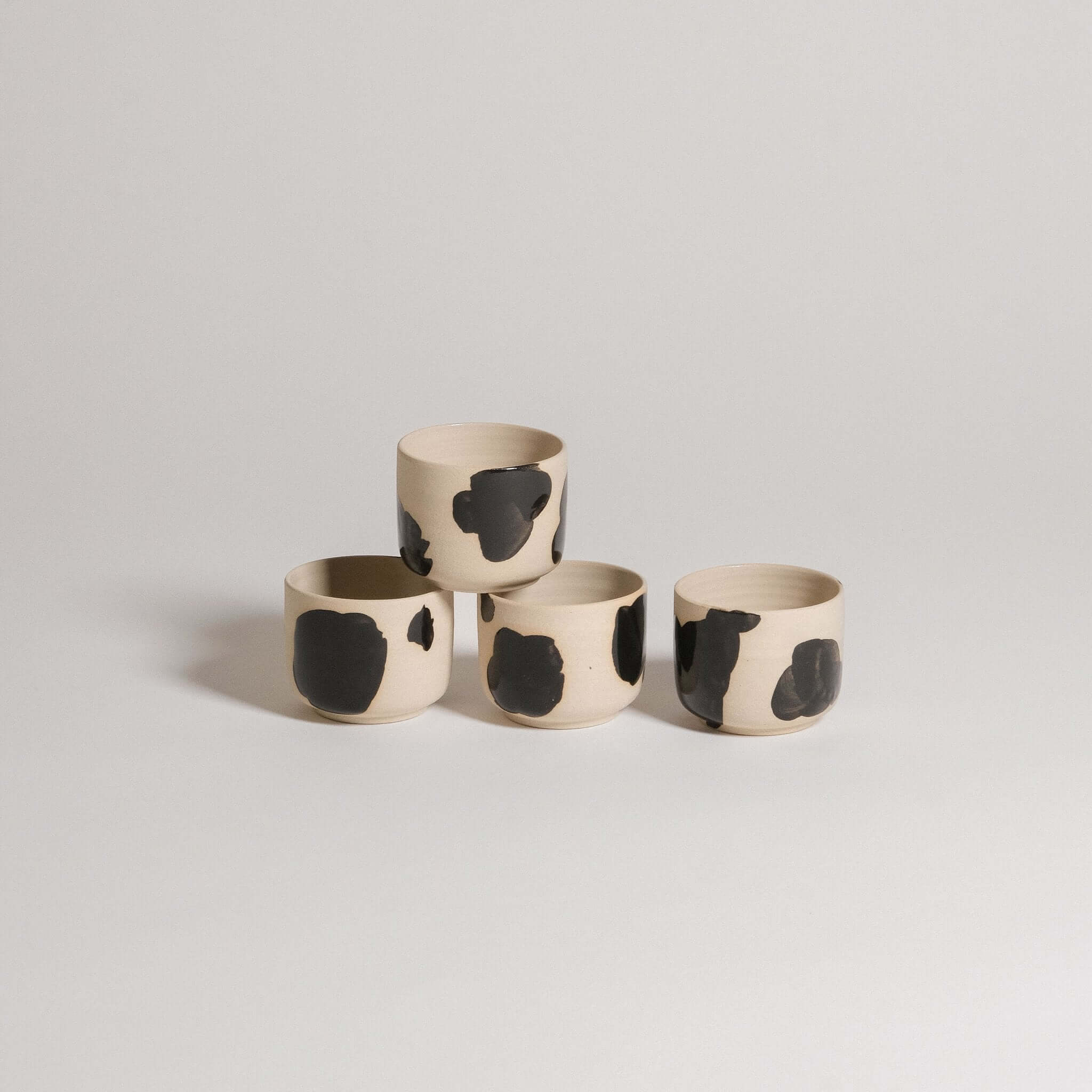 Mix & Match - Cup & Mug Bundle featuring four unique ceramic cups with black and beige designs.