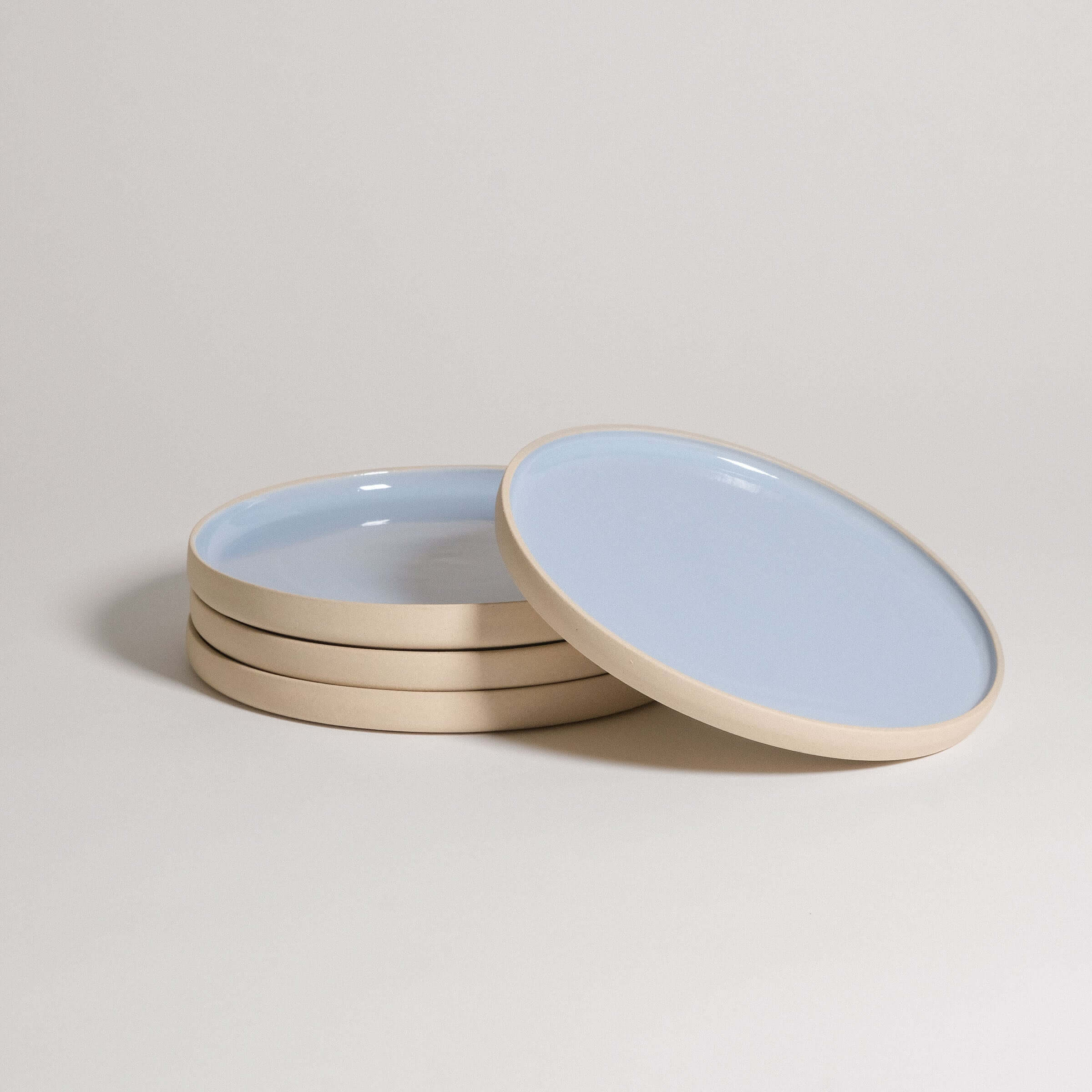 Set of 4 handcrafted stoneware breakfast plates in Iceblue glaze, showcasing unique character and food-safe design.