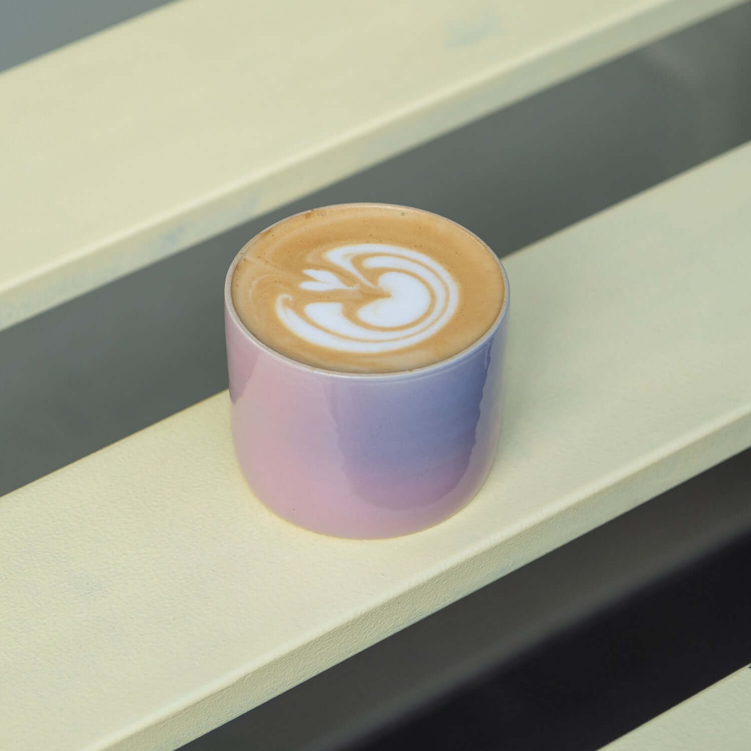 4er Set Kaffeebecher Lilac Sky auf einem Tisch mit einer Kaffeespezialität im Becher.