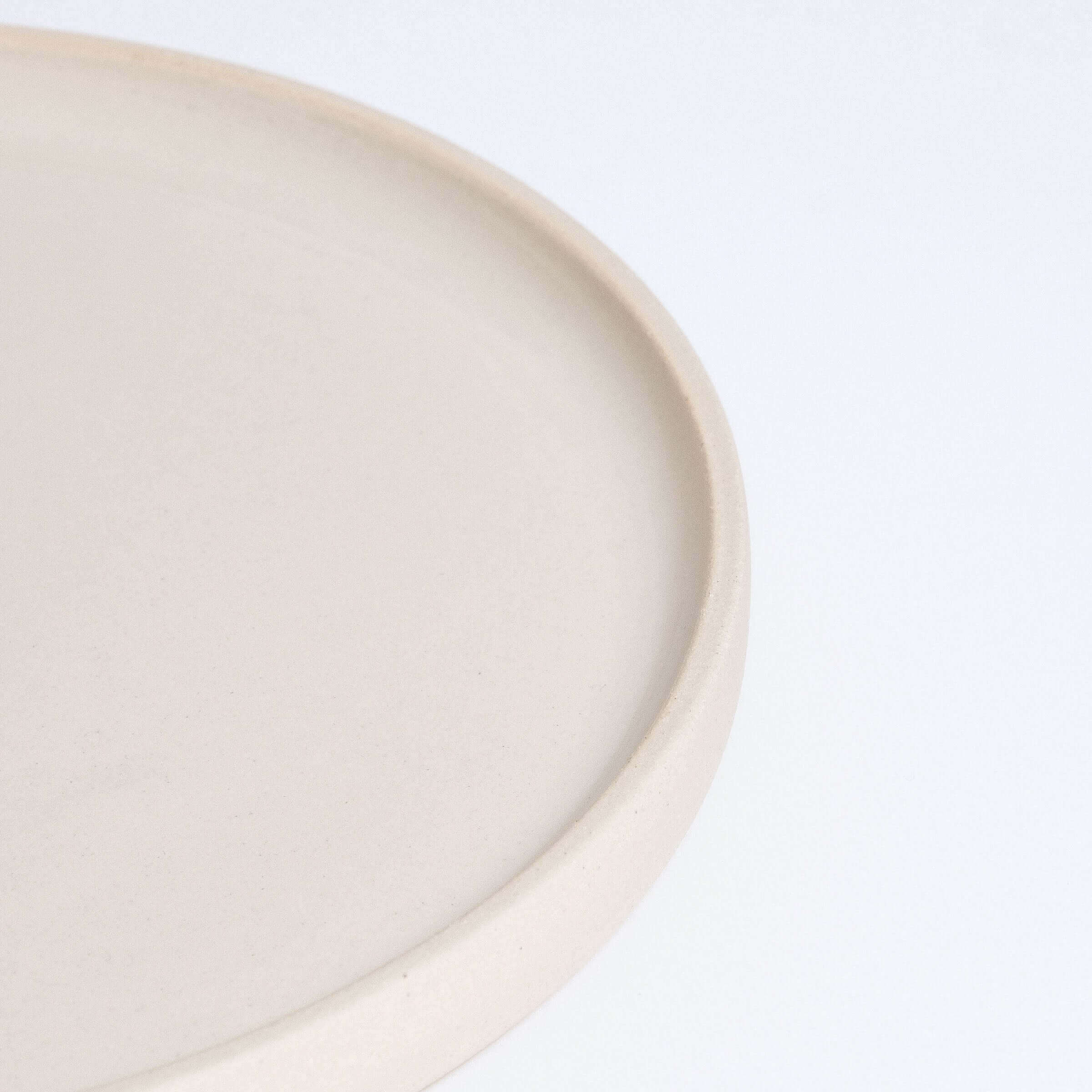 Close-up of a handcrafted creme breakfast plate made from durable stoneware ceramic.