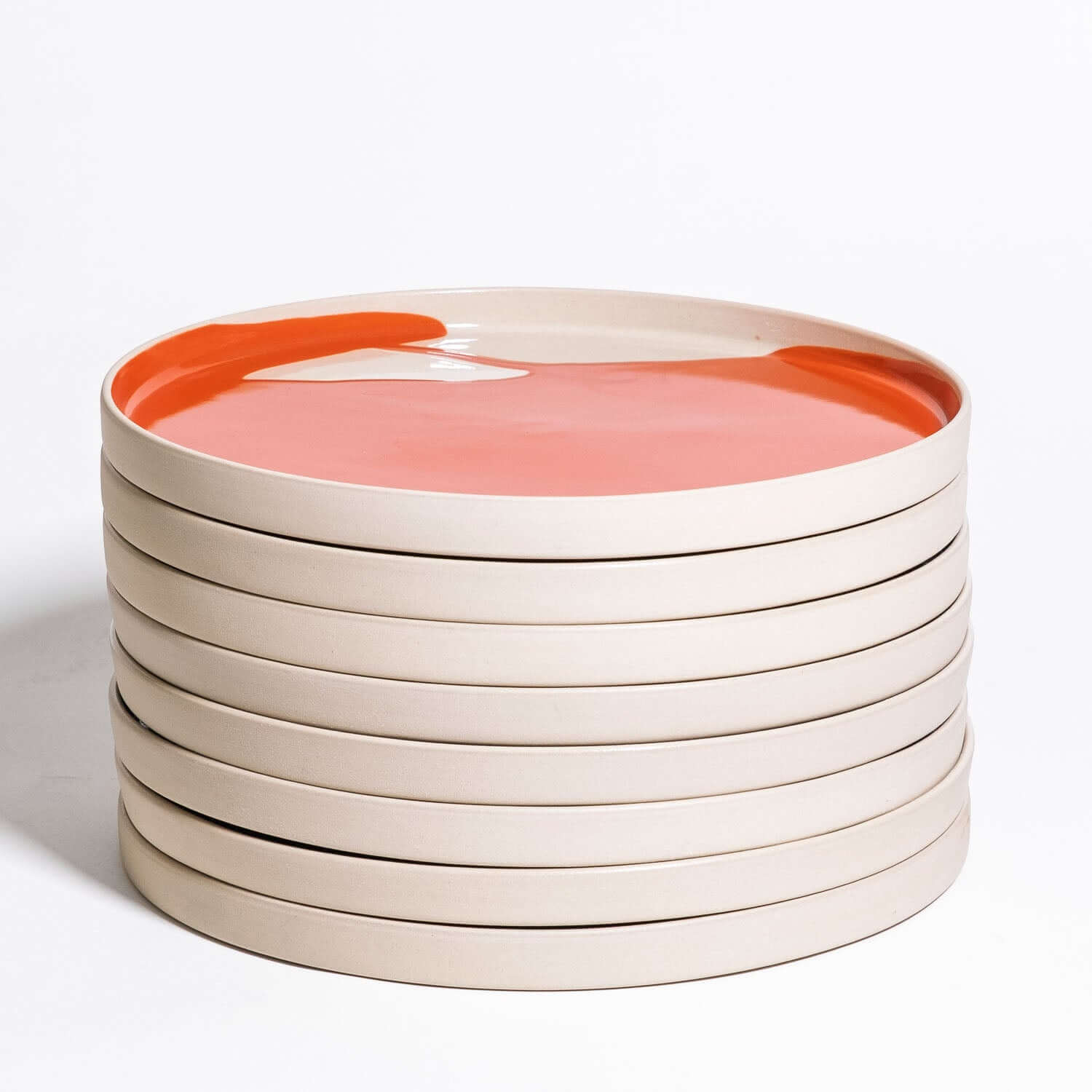 Set of 8 - Dinner Plate – Splash Red: Stapel von acht Steinzeug-Tellern mit rotem Spritzglasur.