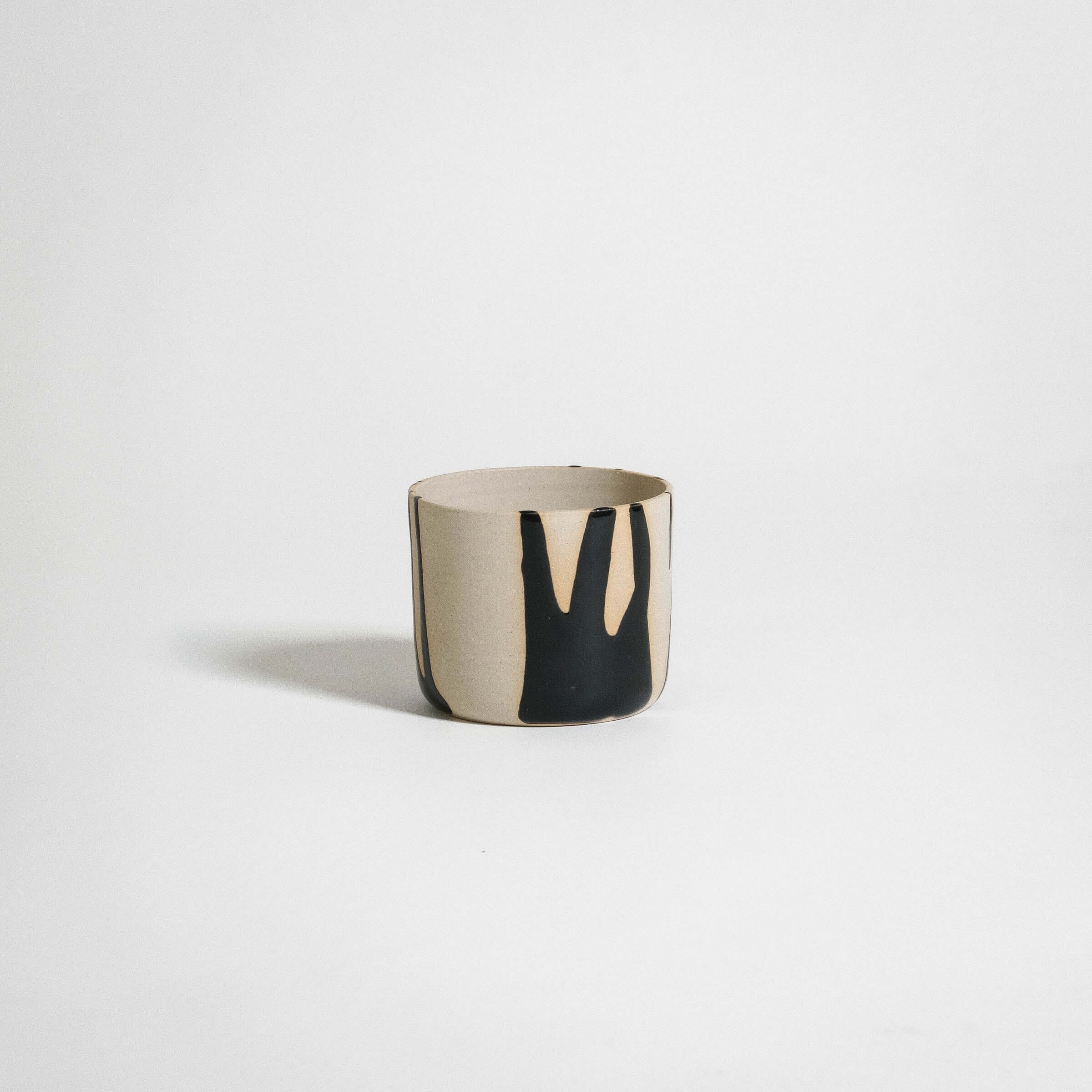 Handcrafted coffee cup in stoneware with glossy black finish and natural clay texture, perfect for daily use.