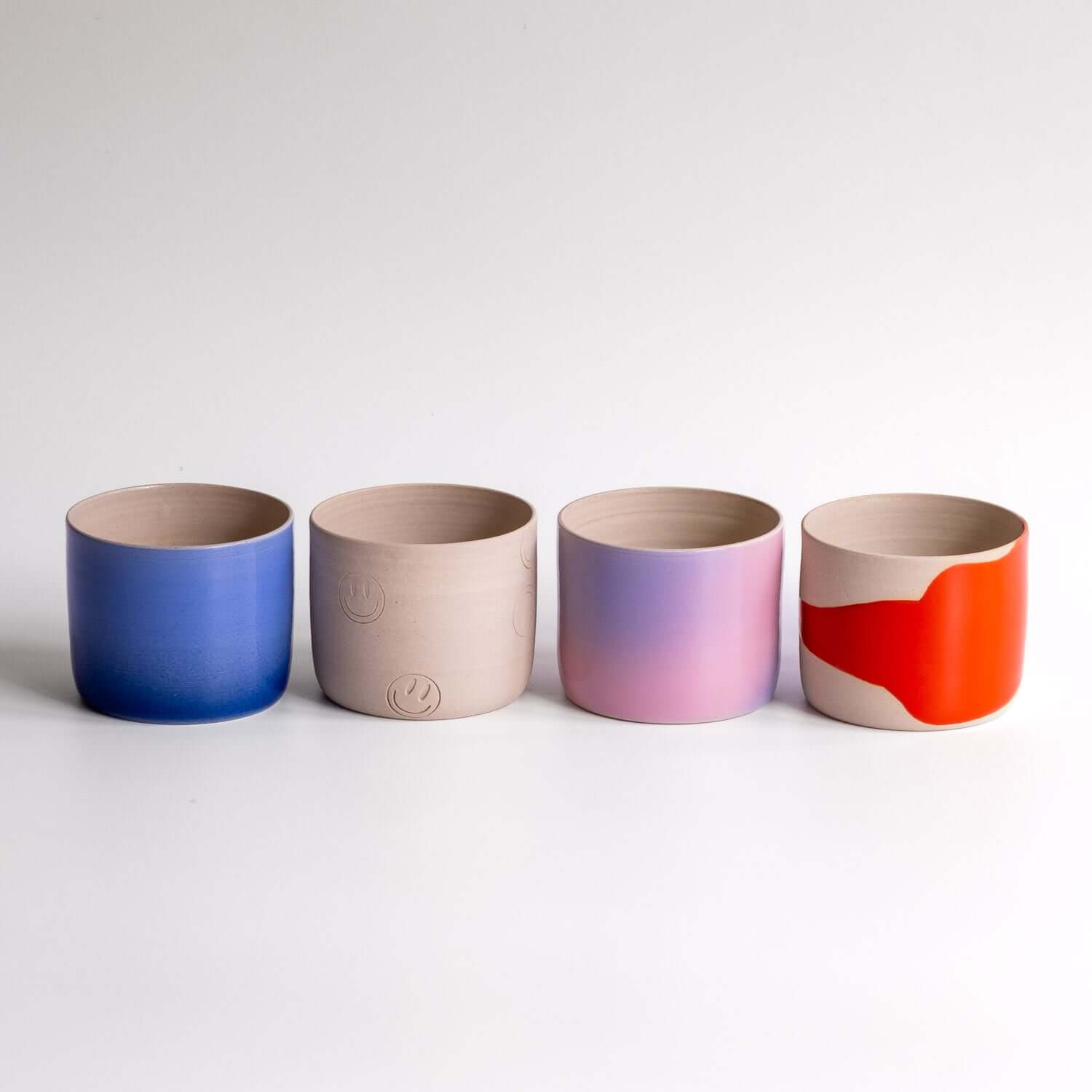 Happy Edition Coffee Cups in various colors and designs, showcasing unique hand-crafted ceramic styles.