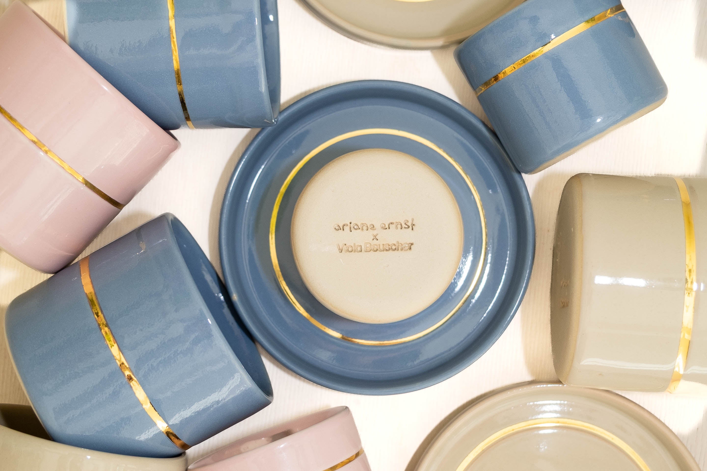Limitierte Keramik Kollektion Ariane Ernst Viola Beuscher mit bunten Tassen und Tellern mit Golddetails.