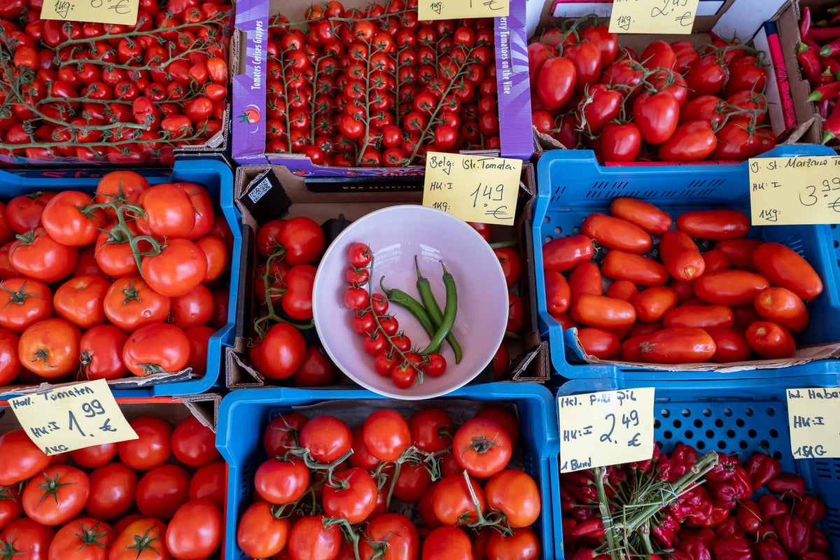 Sommer Essentials: Bunte Auswahl an frischen Tomaten auf dem Markt, perfekt für sommerliche Gerichte.