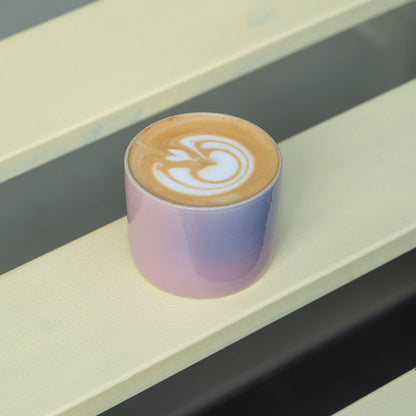 4er Set Kaffeebecher Lilac Sky auf einem Tisch mit einer Kaffeespezialität im Becher.