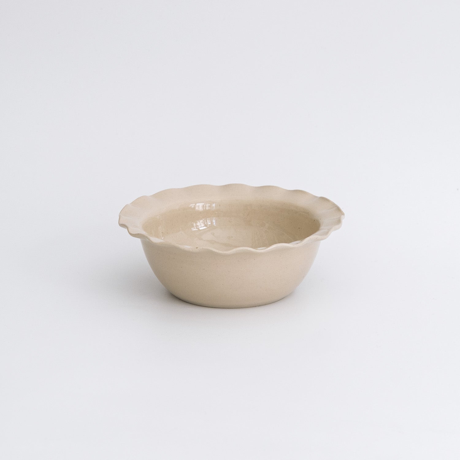 Handgemachte Keramik Frühstücksschale in Cremefarbe mit gewelltem Rand.