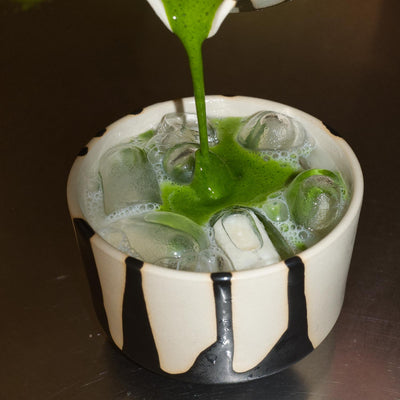 Matcha Set – Otis - Ceremonial Matcha: Grüner Matcha wird in eine dekorative Schale gegossen, umgeben von Eis.