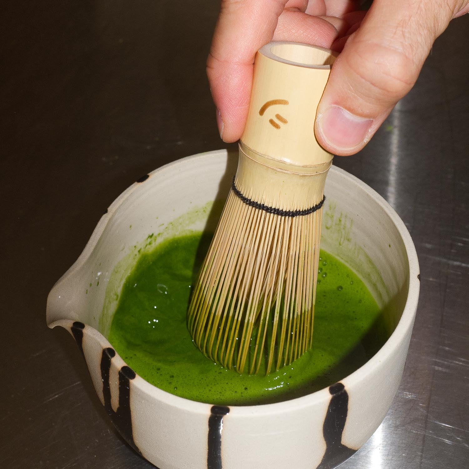 Matcha Pouring Bowl – Otis mit einem Matcha-Besen bei der Zubereitung von grünem Matcha im Inneren.