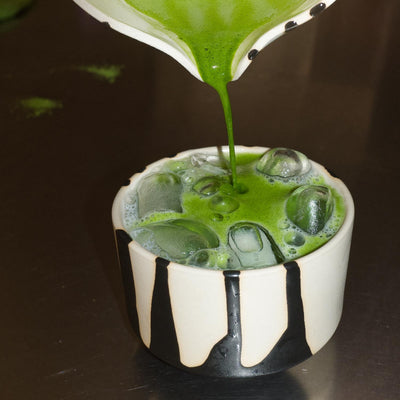 Matcha Cup – Otis mit grünem Matcha, Eiswürfeln und glänzender schwarzer Außenglasur.