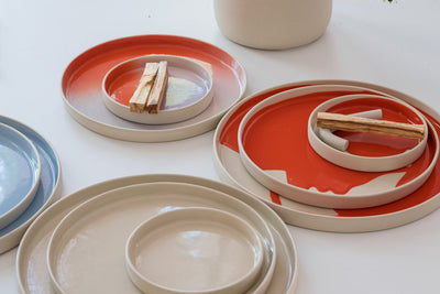 Bunte Keramikteller in verschiedenen Größen und Farben, ideal für moderne Tischdekoration und Servieren.