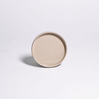 Saucer - Creme, flacher Steinzeuguntersetzer in Cremefarbe mit glänzender Glasur.