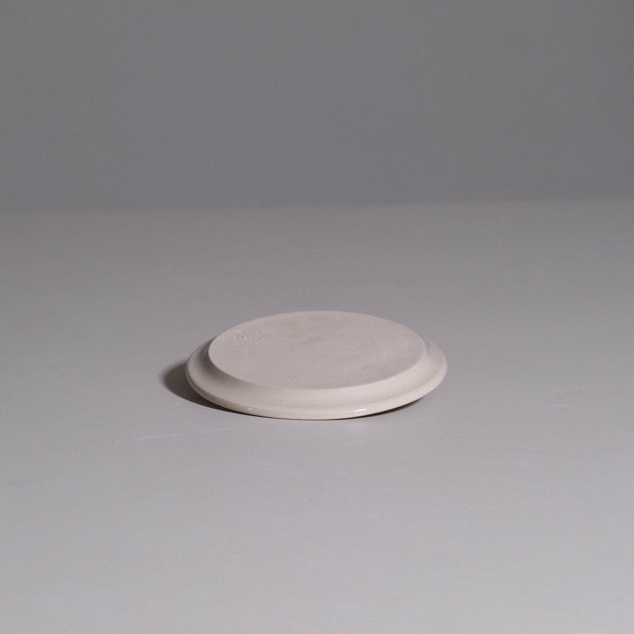 Plate aus handgemachter Keramik in Neo Creme, seitliche Detailansicht.