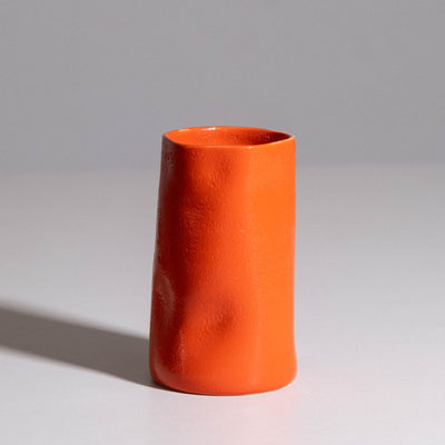 Vase aus handgemachter Keramik mit roter, glänzender Glasur.