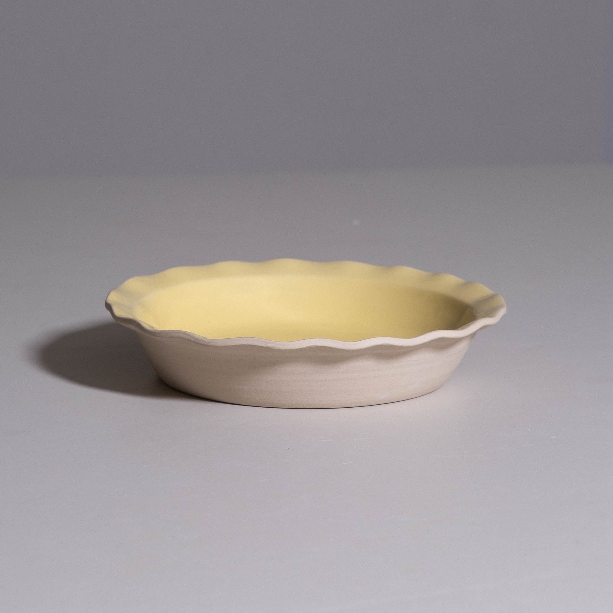 Dinner Bowl aus handgemachter Keramik mit welligem Rand und warmer gelber Glasur.