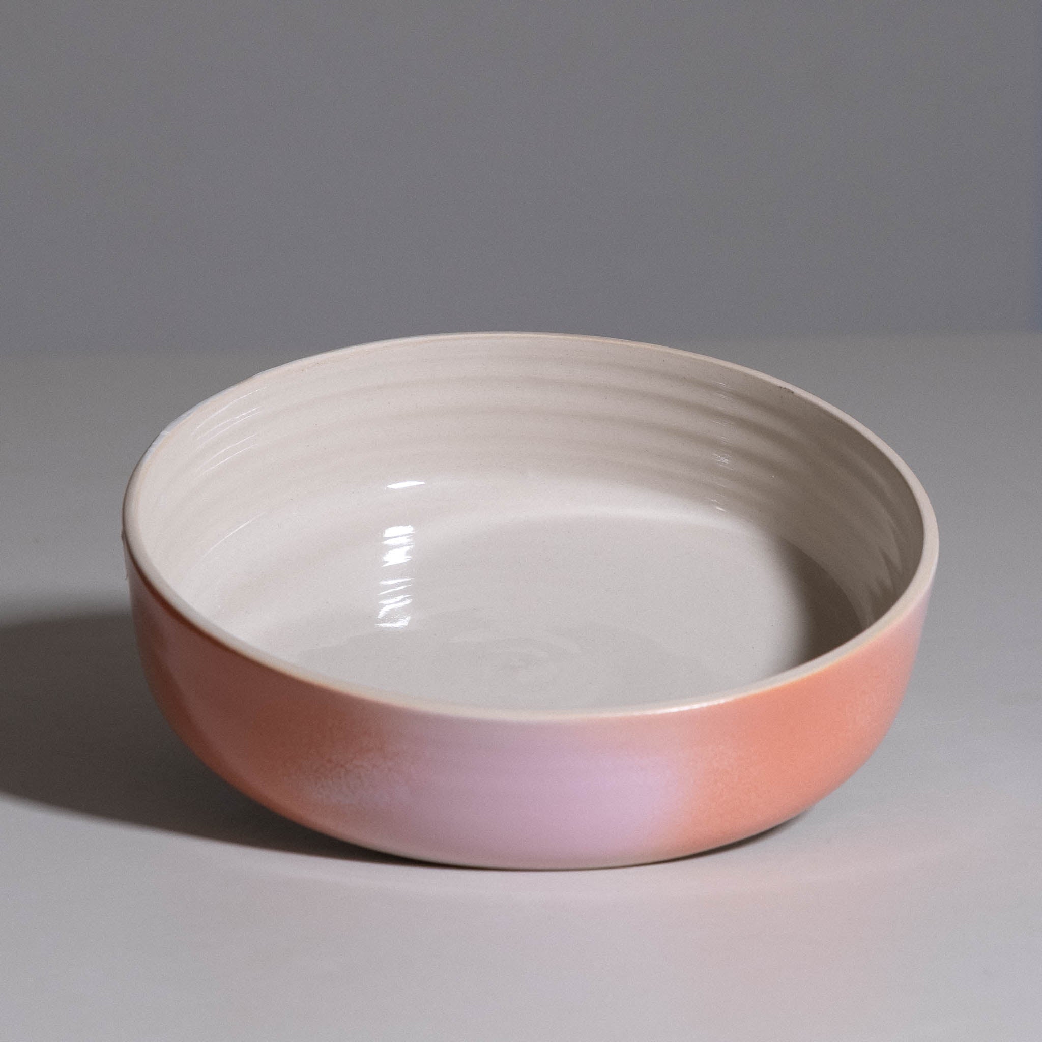 Serving Bowl aus handgemachter Keramik mit cremeweißem Innenraum und rosa-koralle Verlauf.