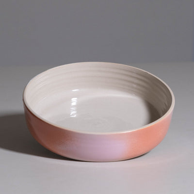 Serving Bowl aus handgemachter Keramik mit cremeweißem Innenraum und rosa-koralle Verlauf.