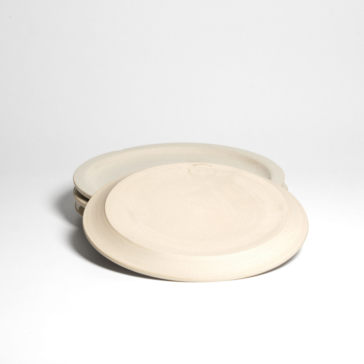 Creme bistro plate – underside above a stack of plates.