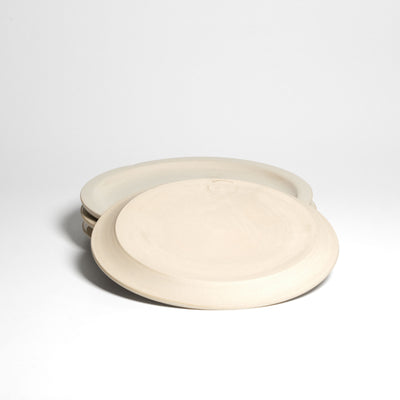 Creme bistro plate – underside above a stack of plates.