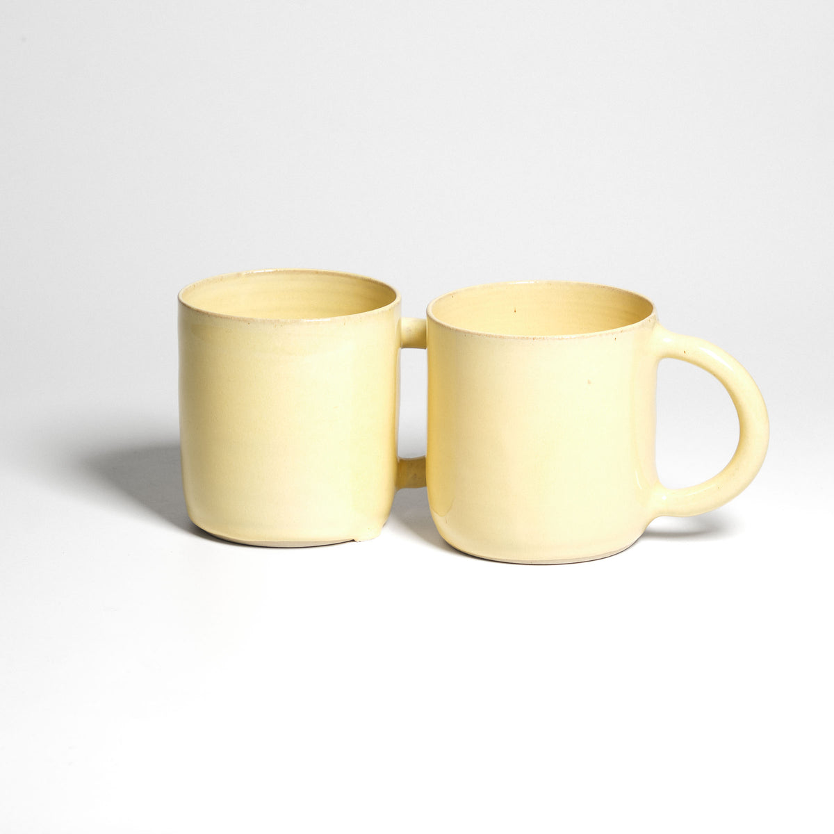 Yellow Pankratiushof mug with handle – two mugs side by side.