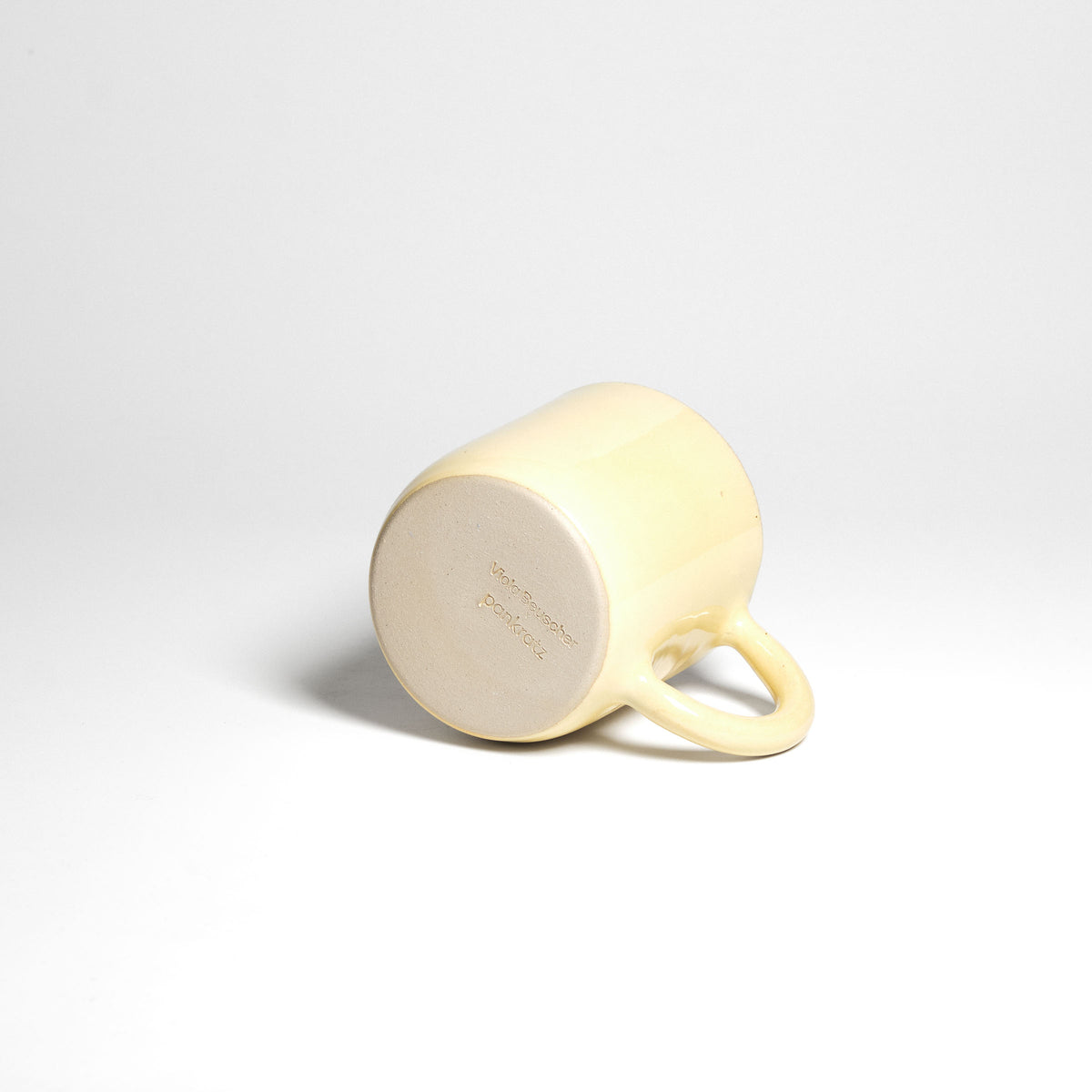 Yellow Pankratiushof mug with handle – underside of a mug lying on its side.