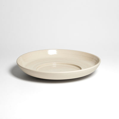 Weite flache cremefarbene Schale – Seitenansicht.