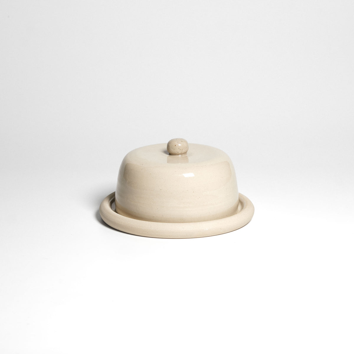 Cremefarbene Butterdose mit Deckel und Teller – geschlossene Dose.