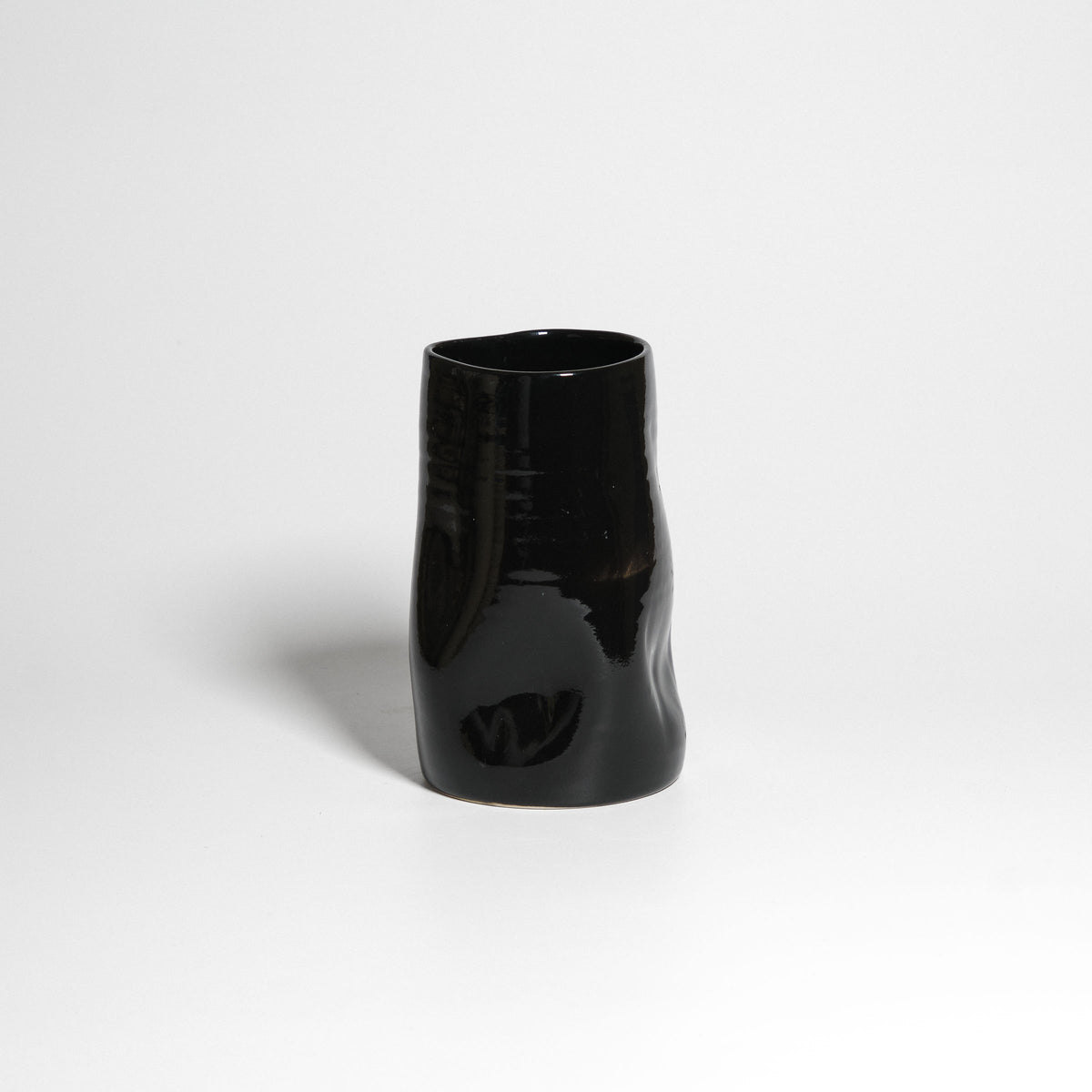 Glänzend schwarze Vase mit sanft unregelmäßigen Wänden – Vorderansicht.