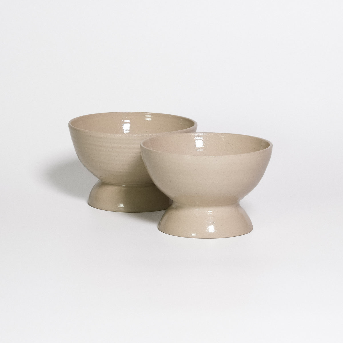 Two Dessert Dishes Creme side by side, footed stoneware dishes with transparent glossy glaze